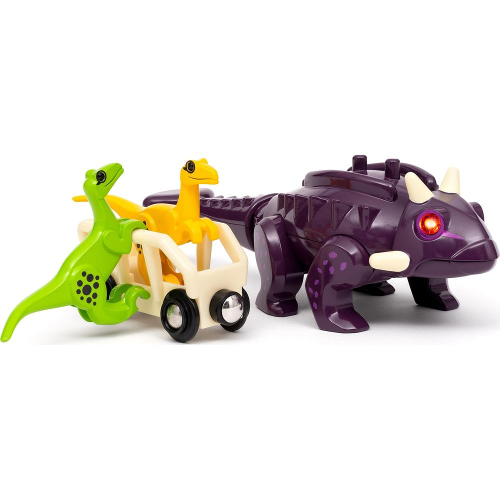 Drei Dinosaurier-Spielzeuge: lila Triceratops, gelber und grüner Raptor auf einem Wagen.