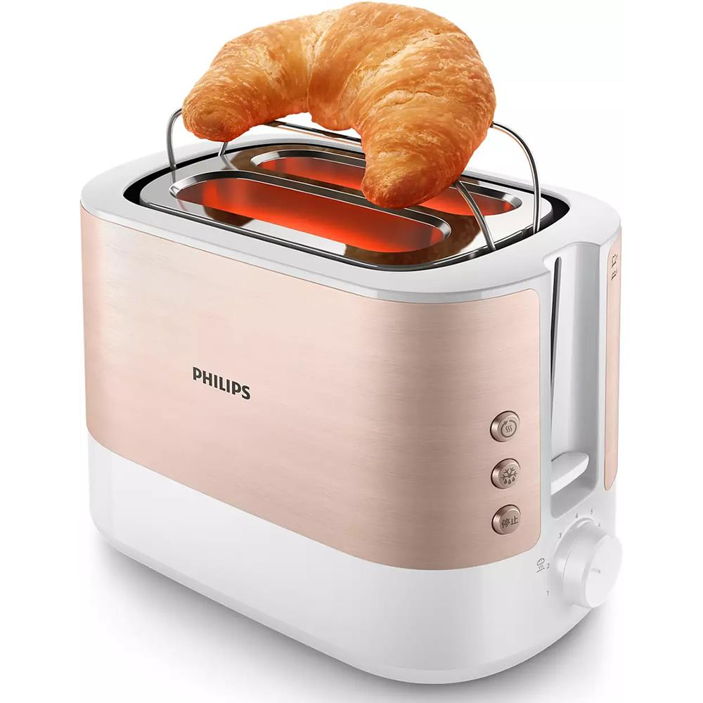Gül altın rengi Philips tost makinesi, yuvaların üzerinde duran kruvasan ile.