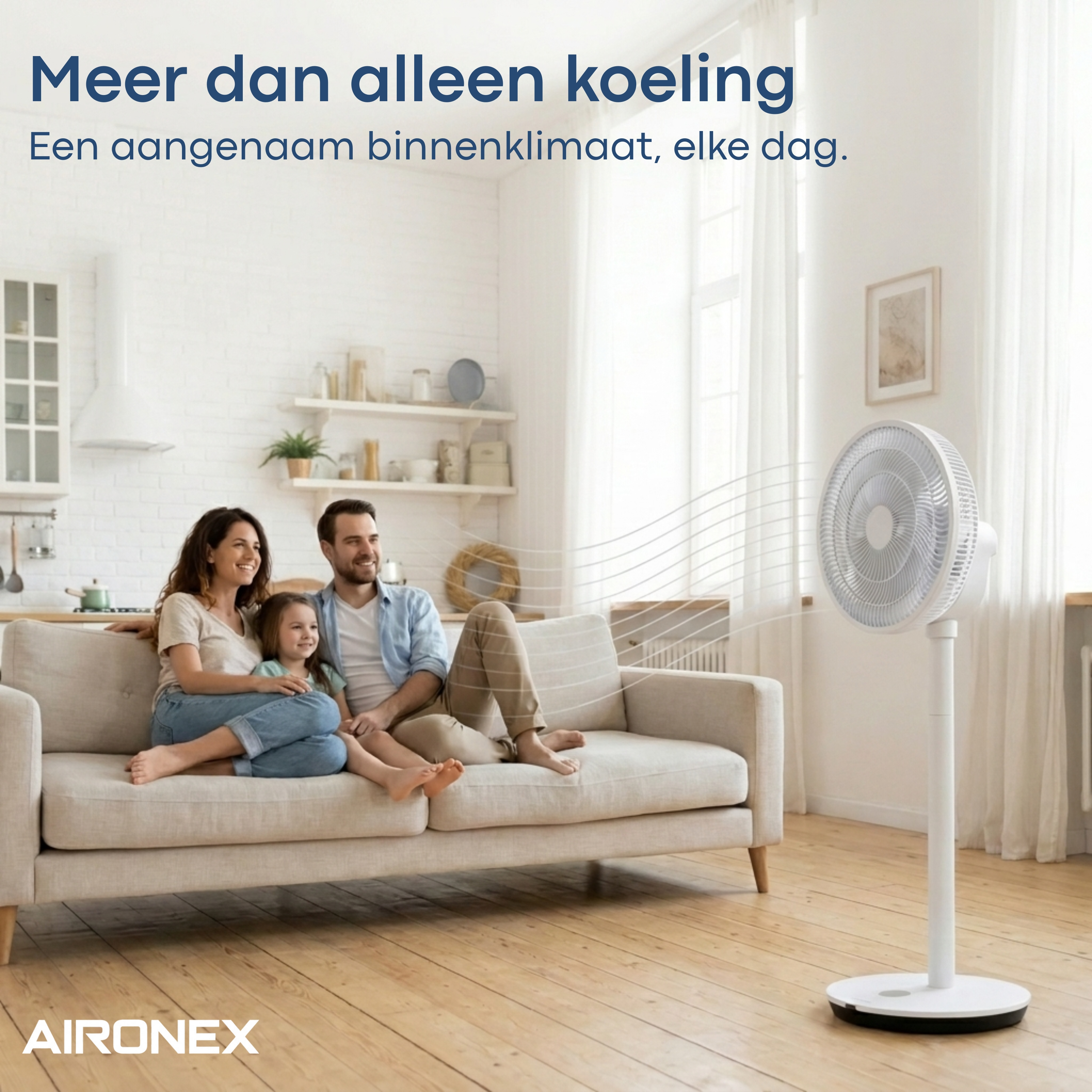 Familie zit op bank, ventilator op voorgrond, keuken op achtergrond.