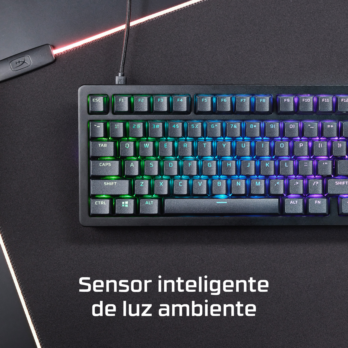 Un primer plano de un teclado negro iluminado con RGB sobre una superficie oscura.