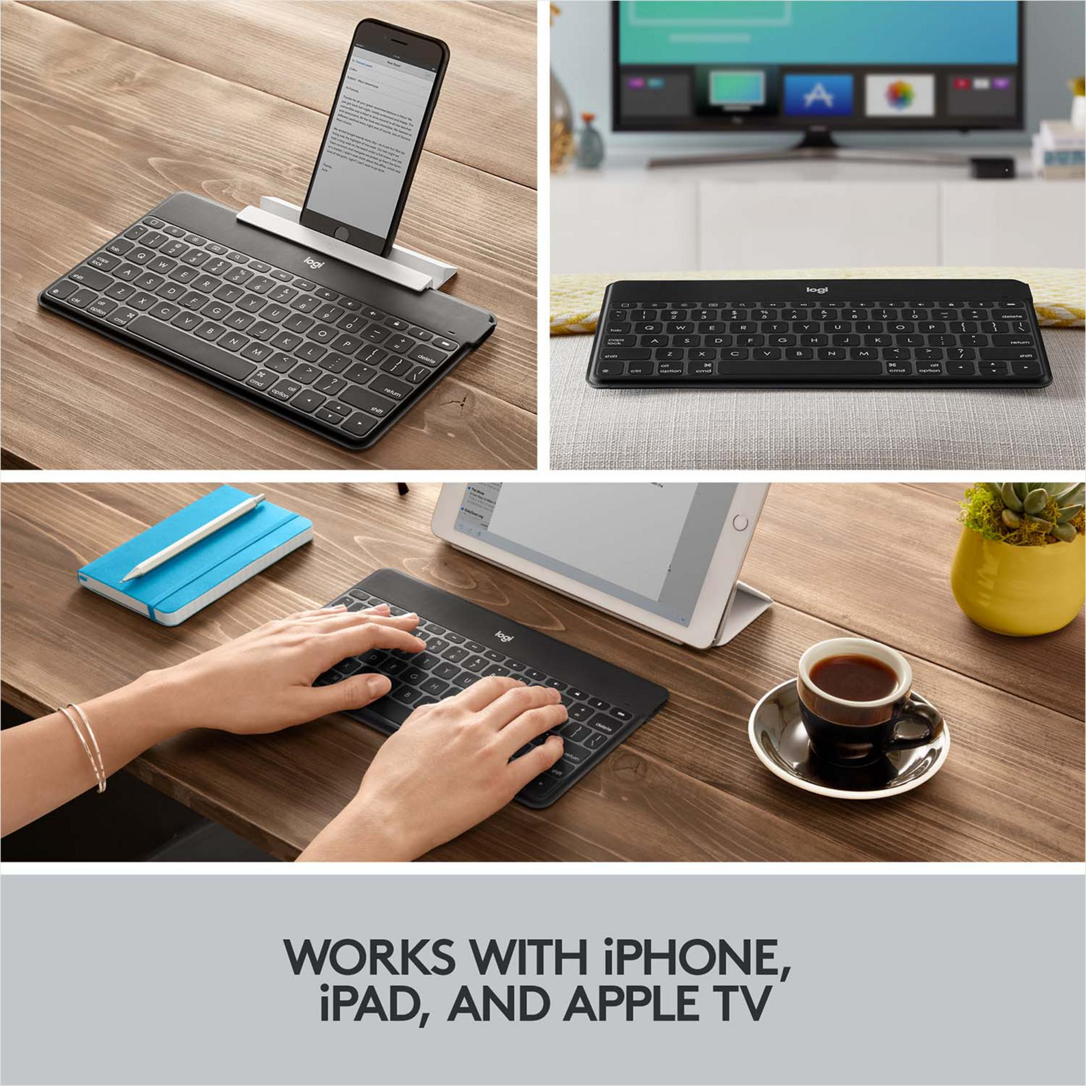 Ein Smartphone auf einer Tastatur, daneben eine Tastatur vor einem Fernseher, darunter eine Person, die tippt.