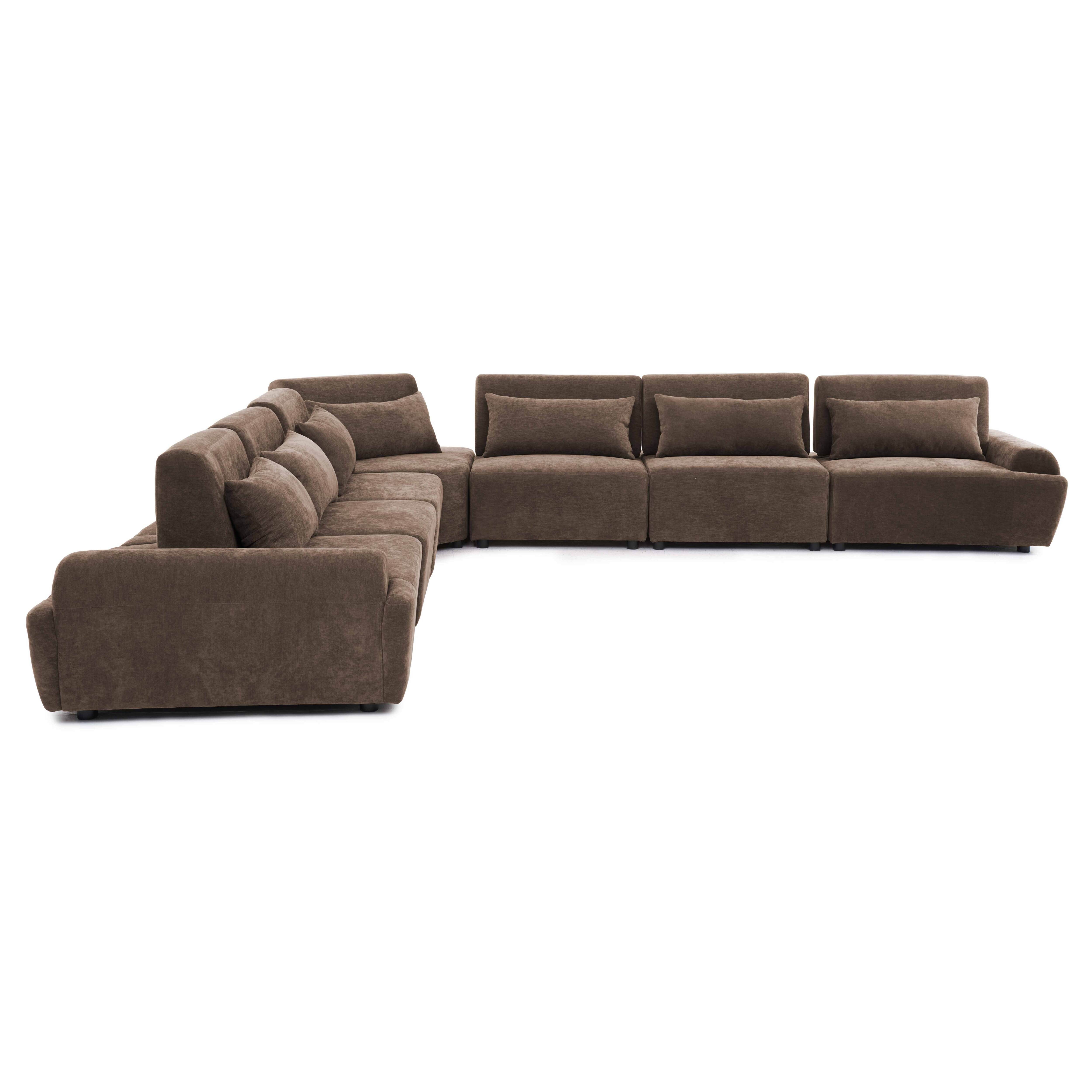 Ein braunes Ecksofa mit mehreren Kissen vor einem weißen Hintergrund.