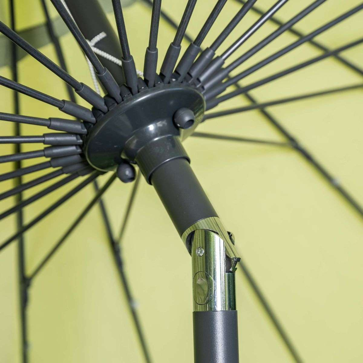 Close-up van een parasol met donkere baleinen tegen een gele achtergrond.