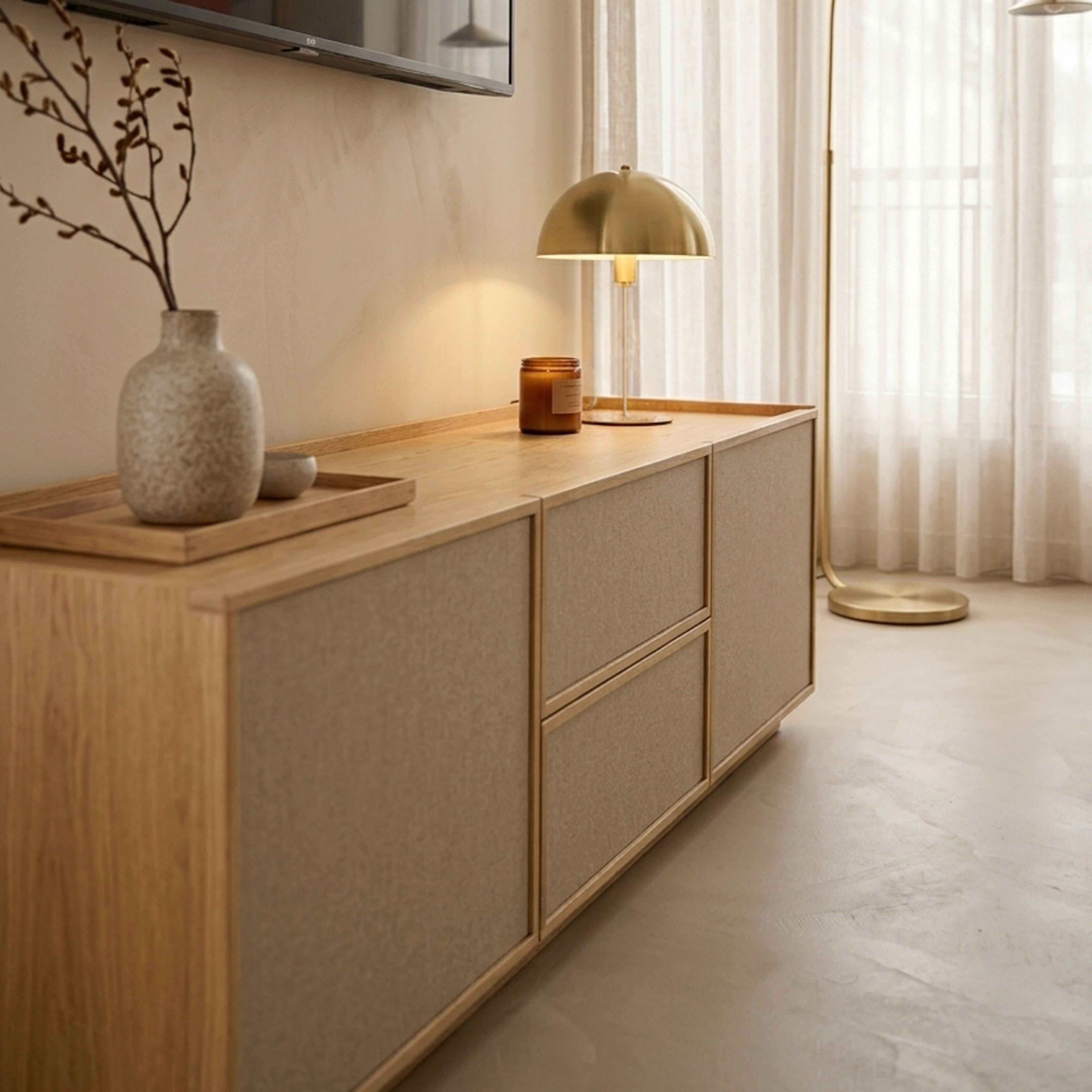 Holzkommode mit Vasen, Kerze, Lampe und Vorhängen im Hintergrund.