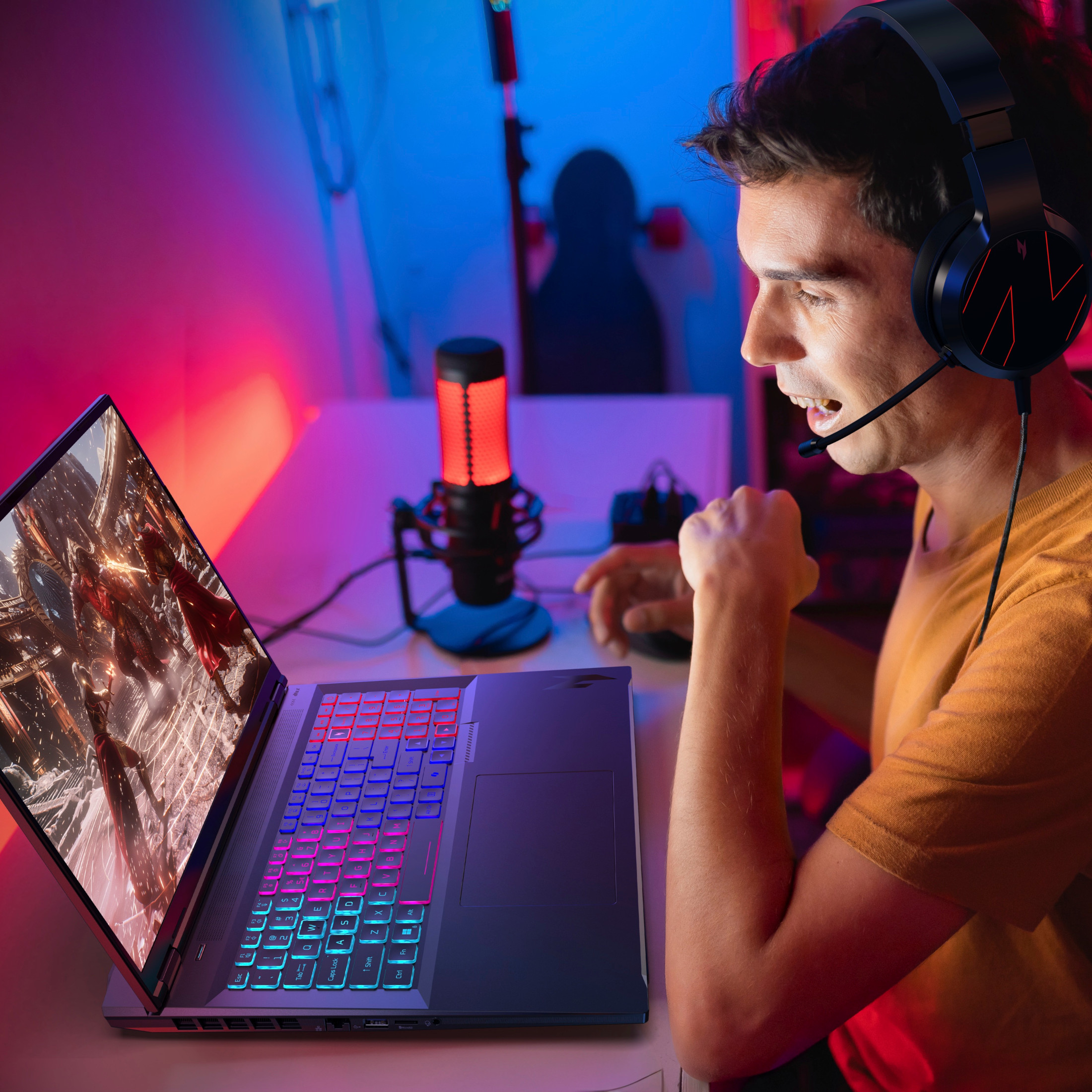 Ein Mann mit Kopfhörern spielt ein Videospiel auf einem Laptop mit RGB-Tastatur.