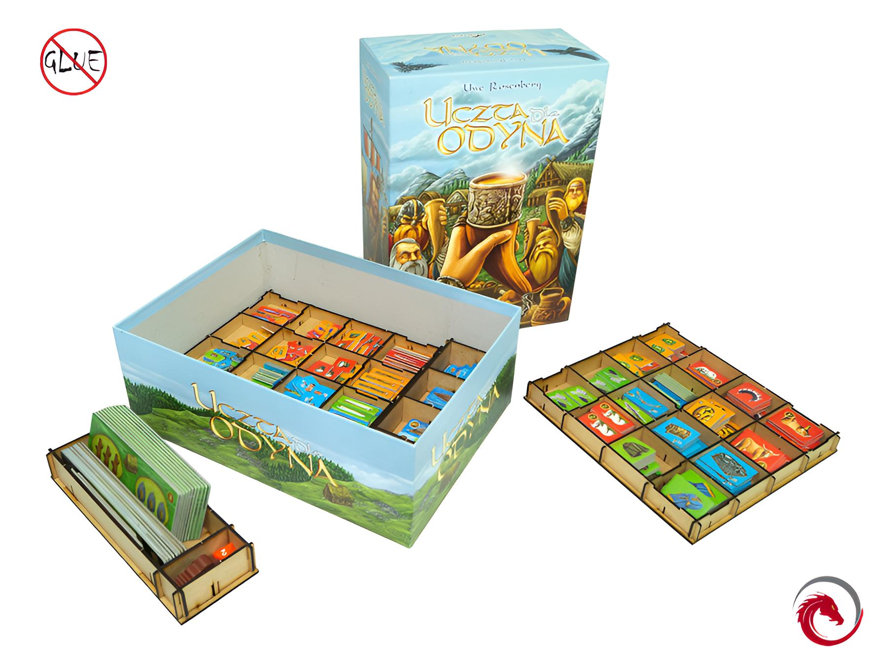 Spielbrett, Karten und Spielsteine in Holzeinsätzen, neben einer Spielschachtel.