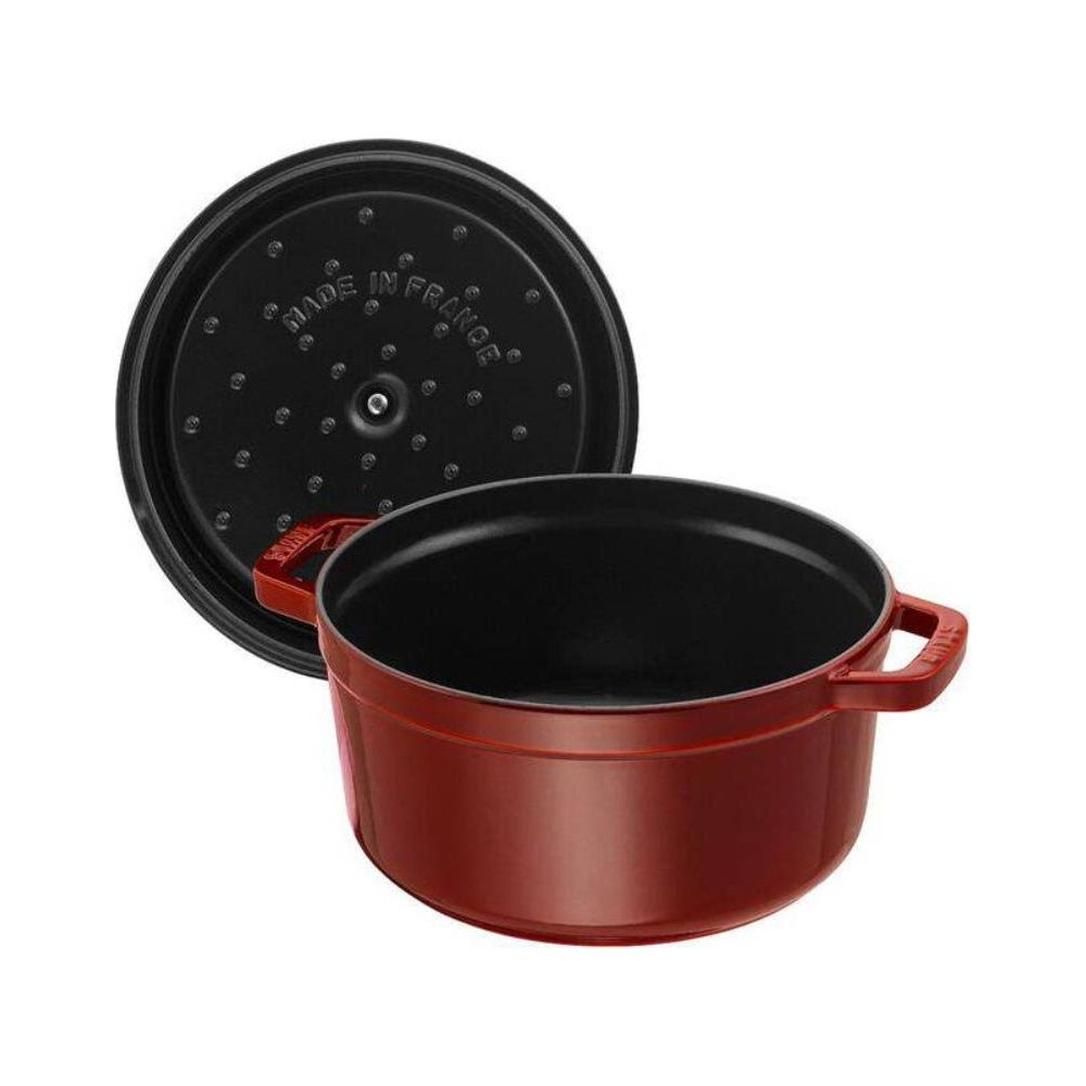 Eine rote Kochtopf mit schwarzem Deckel, auf dem "Made in France" steht.