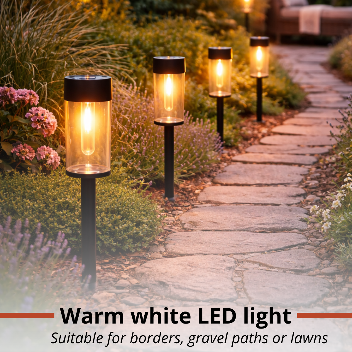 Garden path lit by warm white LED lights, flanked by plants and flowers.