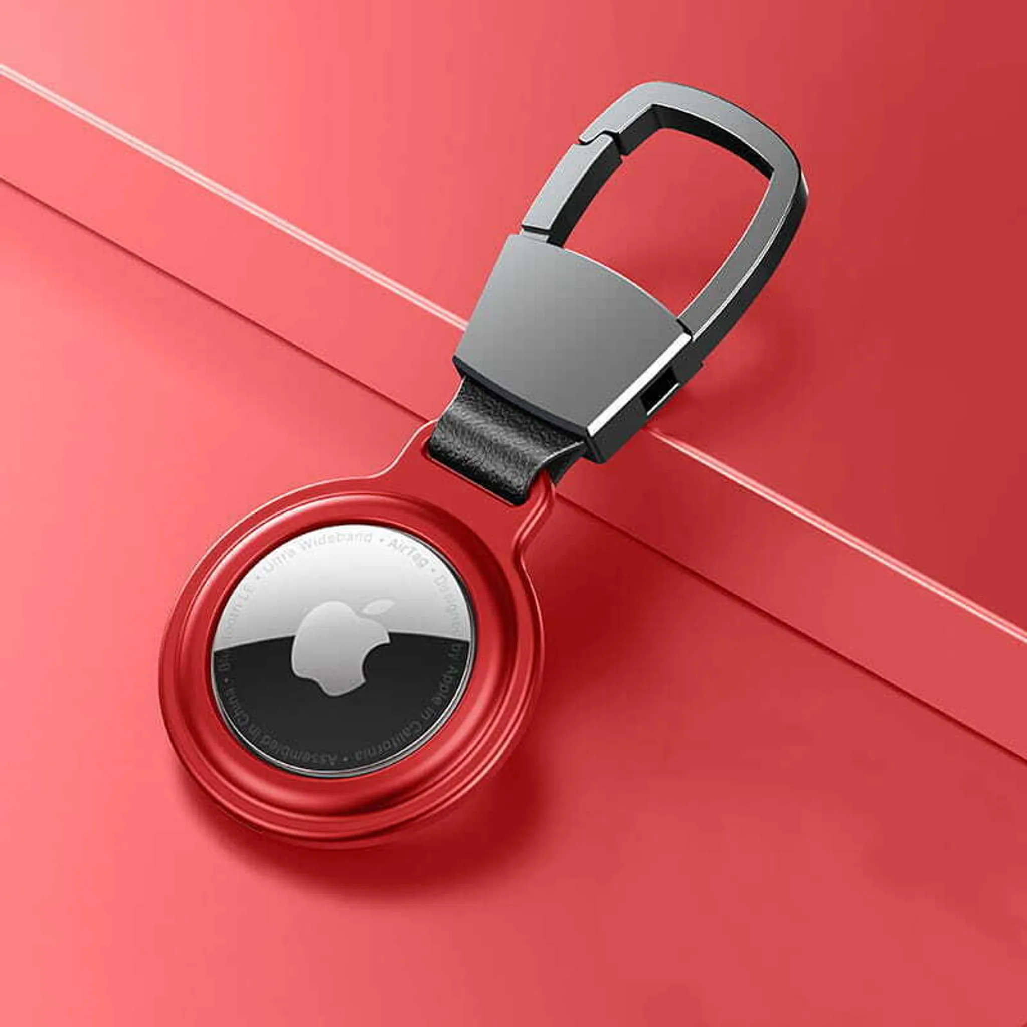 Rot-goldener Schlüsselanhänger mit Apple AirTag und Karabinerhaken auf rotem Hintergrund.