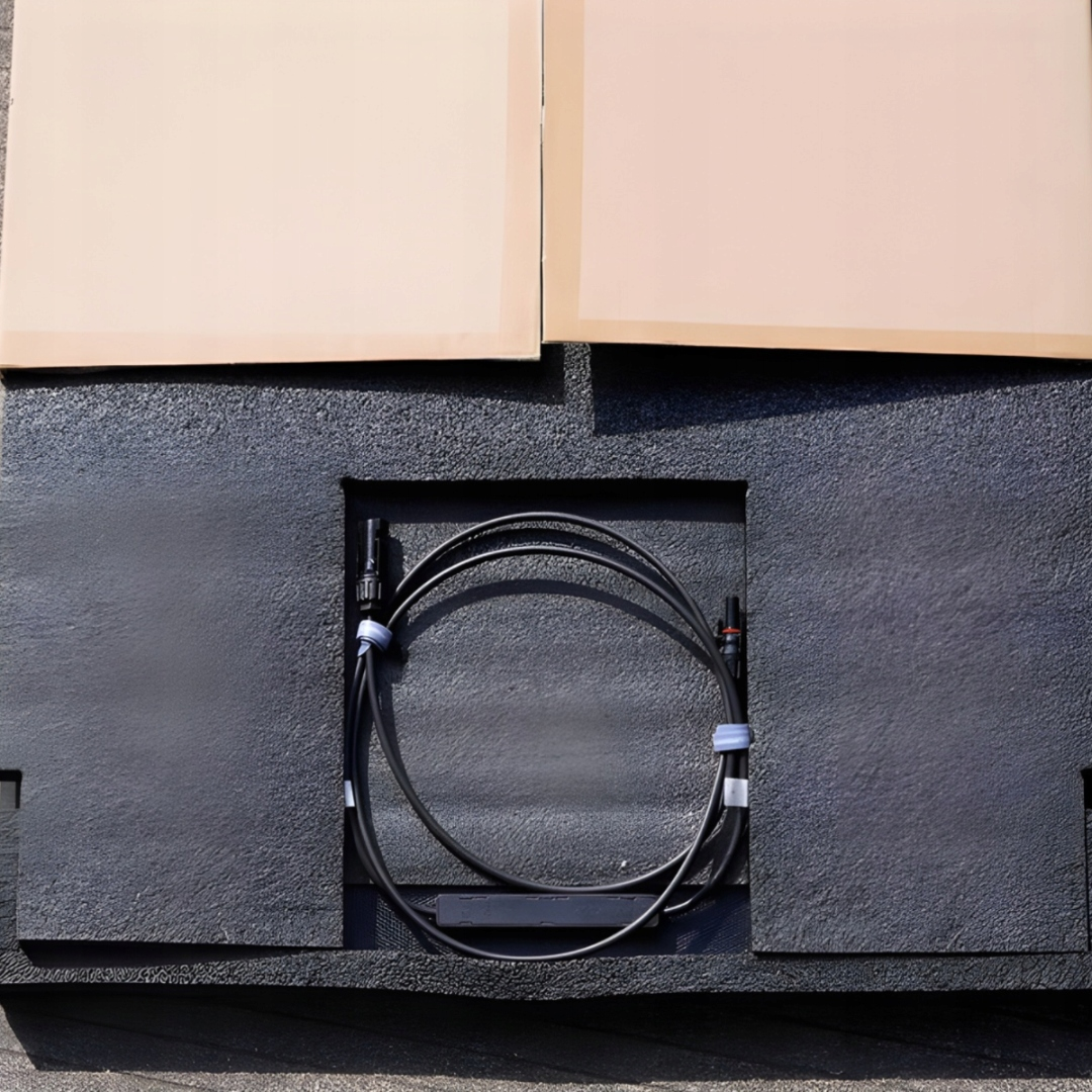 Czarny kabel zwinięty w kółko na czarnej piance, z dwoma złączami.