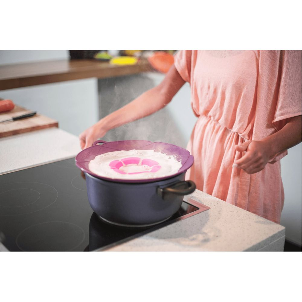 Eine Person in einem rosa Kleid kocht auf einem Induktionskochfeld.
