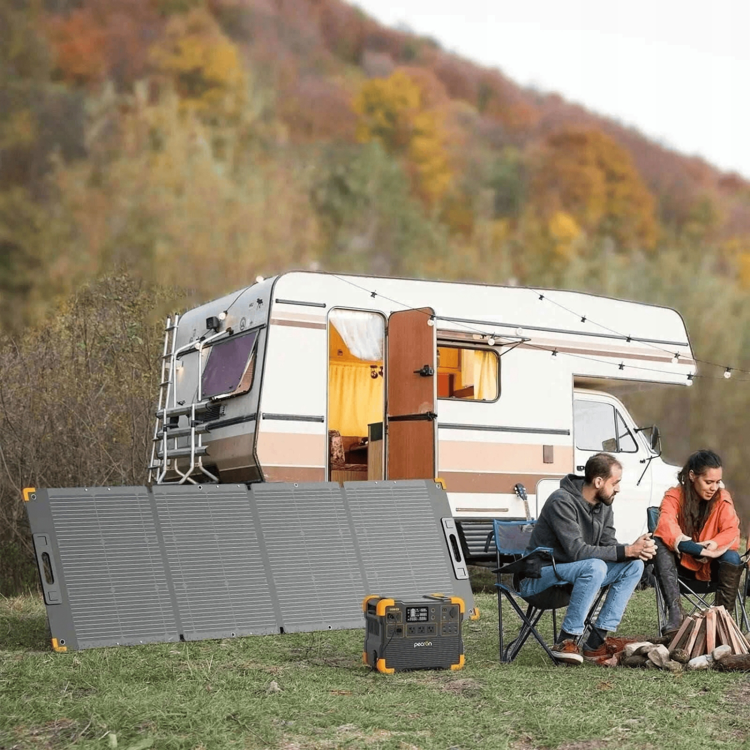 Para kempuje przy kamperze z panelem słonecznym, stacją zasilania i ogniskiem.