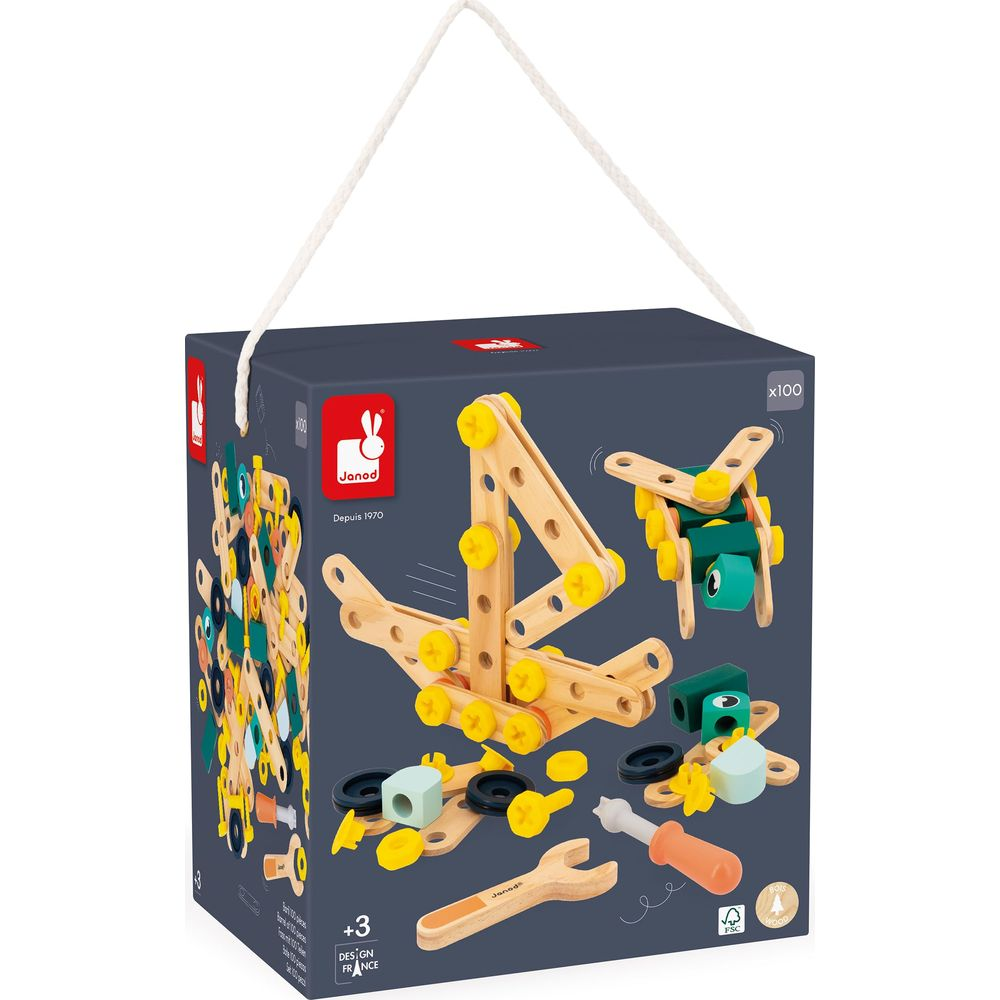 Blocs de construction en bois avec vis jaunes, outils et pièces vertes sur une boîte.
