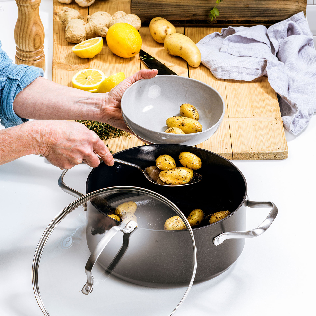 Kleine Kartoffeln werden mit einem Löffel aus einem Topf in eine Schüssel gegeben.