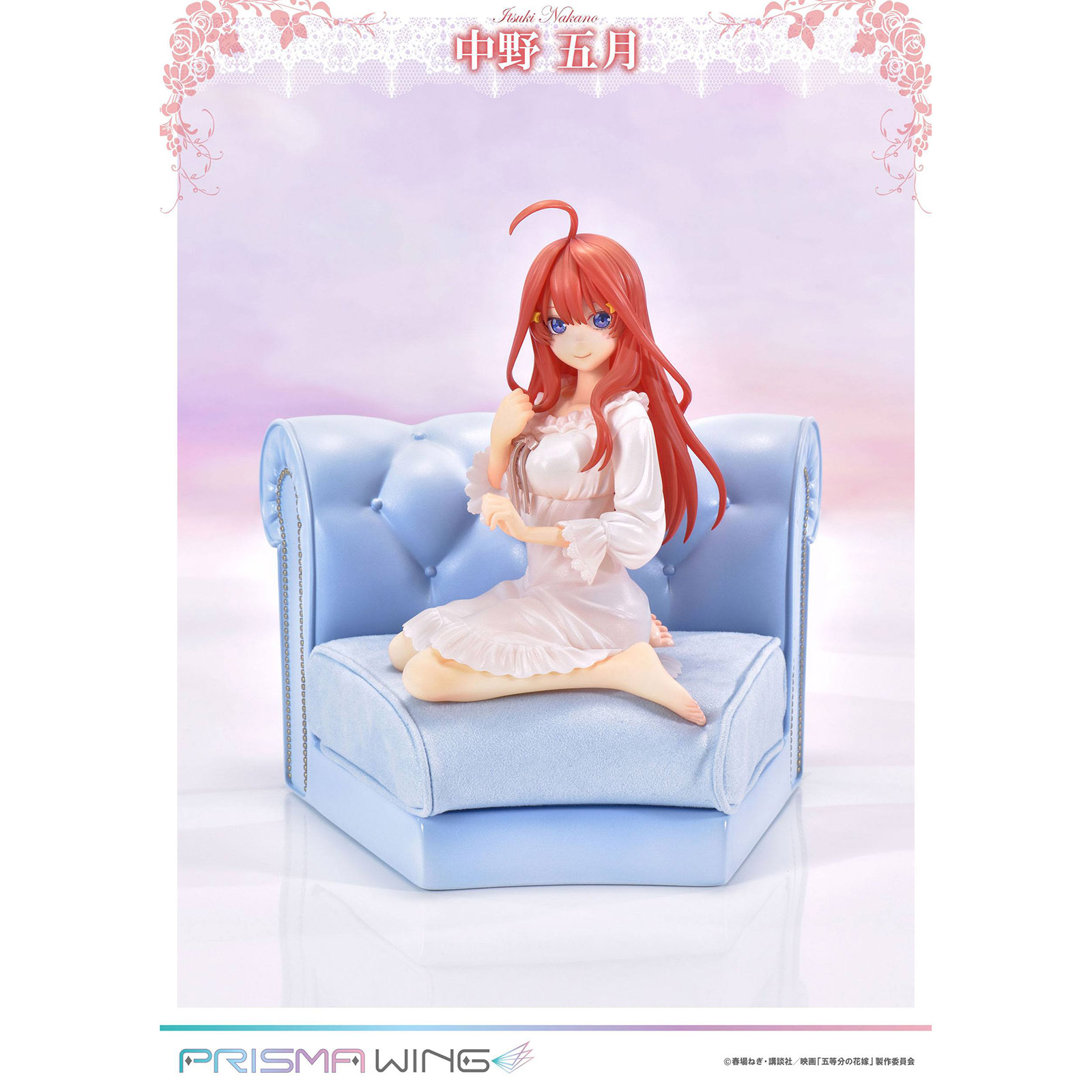 Anime-Figur mit orangenem Haar sitzt auf einem hellblauen Sofa.
