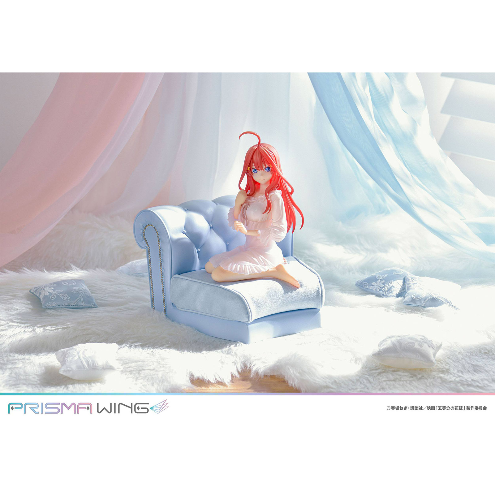 Anime-Figur auf einem blauen Sessel, umgeben von flauschigem Teppich und Kissen.