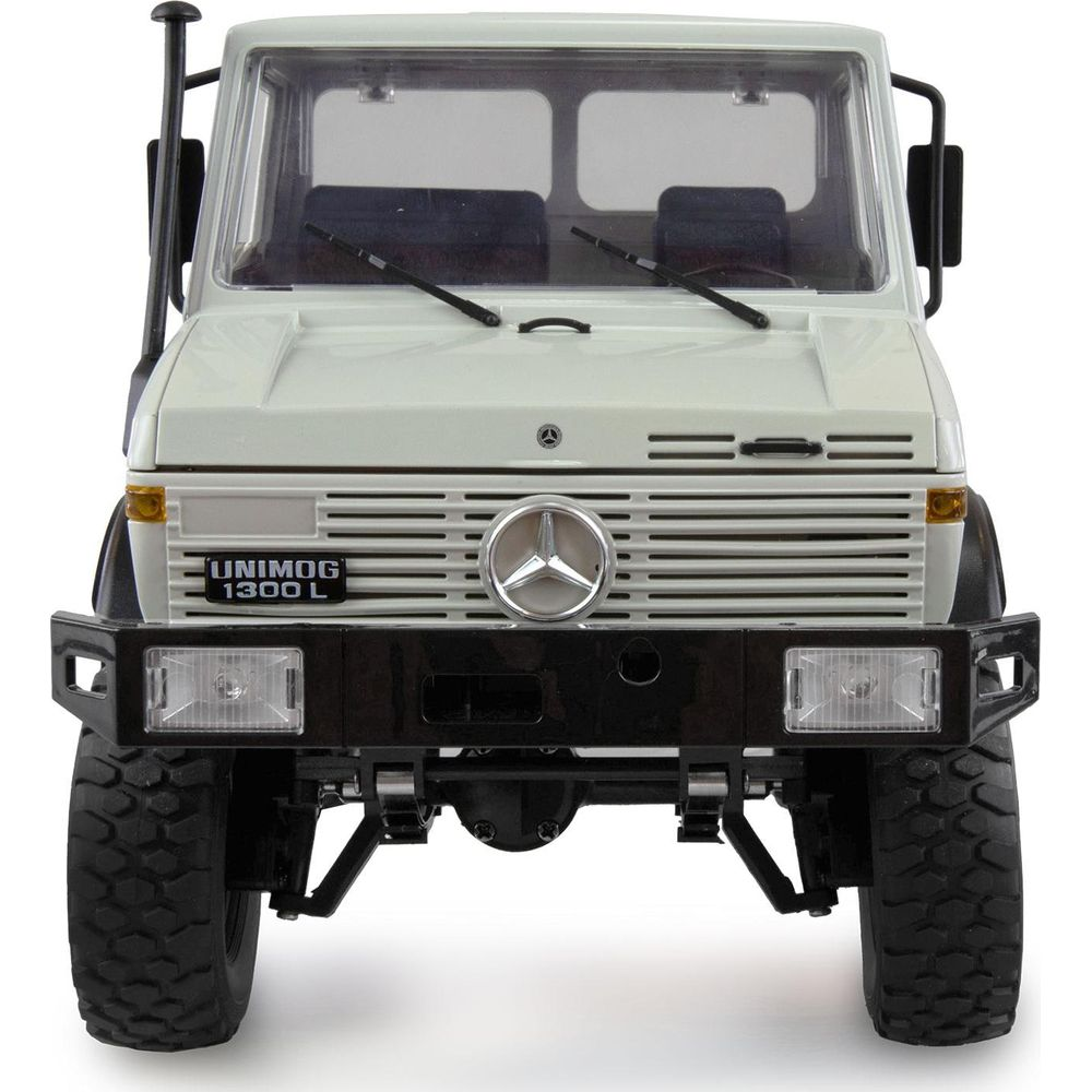 Un Mercedes Unimog 1300 L beige con parrilla y parachoques negros.