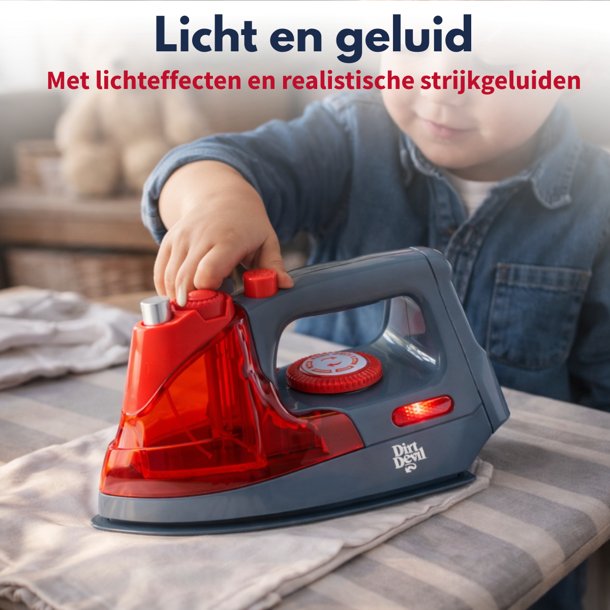 A child plays with a toy iron on an ironing board. Red and gray.