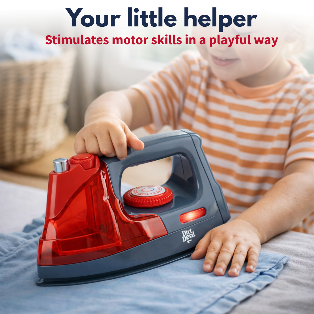 A child plays with a toy iron resting on blue fabric.