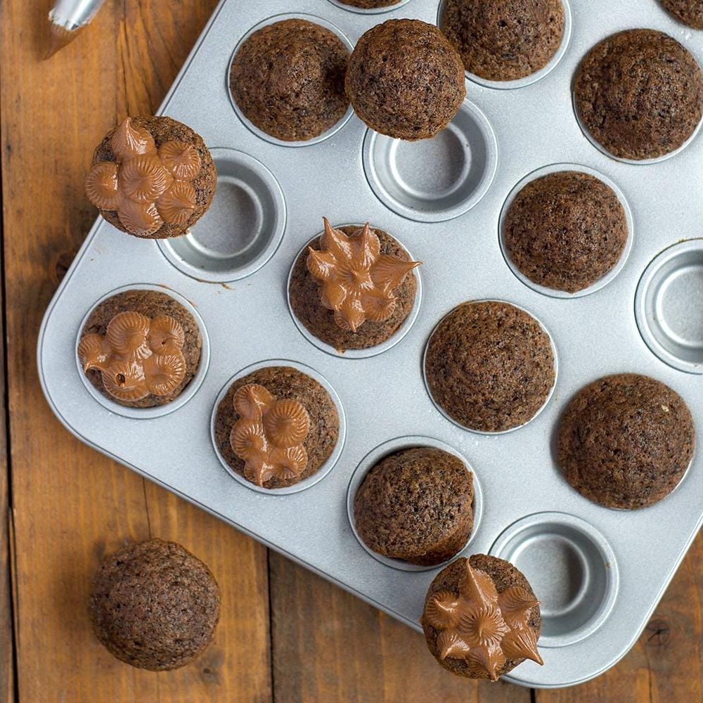 Schokoladenmuffins in einer Backform, einige mit Schokoladenglasur garniert.