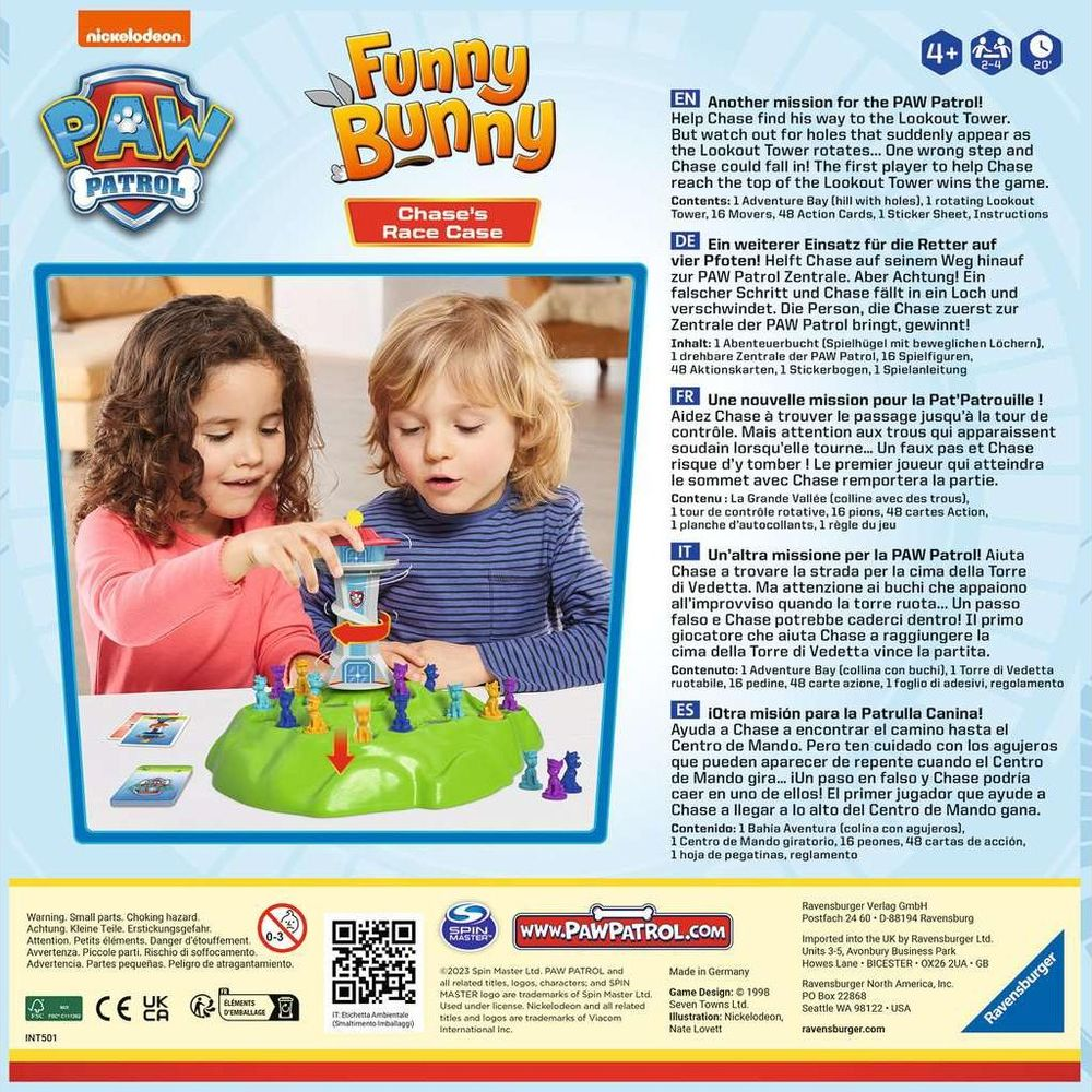 Due bambini giocano a un gioco da tavolo Paw Patrol con una torre rotante e pedine.