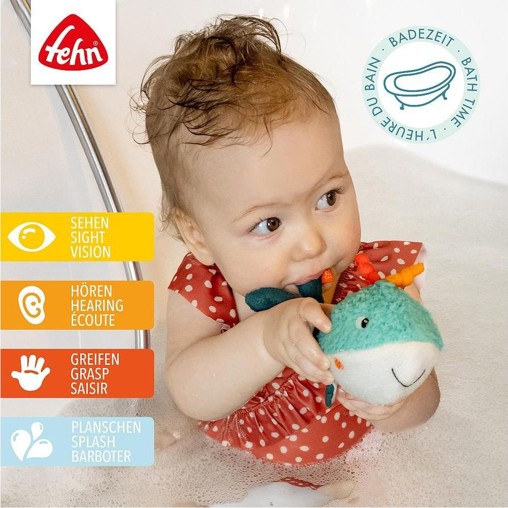 Ein Baby in der Badewanne spielt mit einem Wal-Spielzeug.