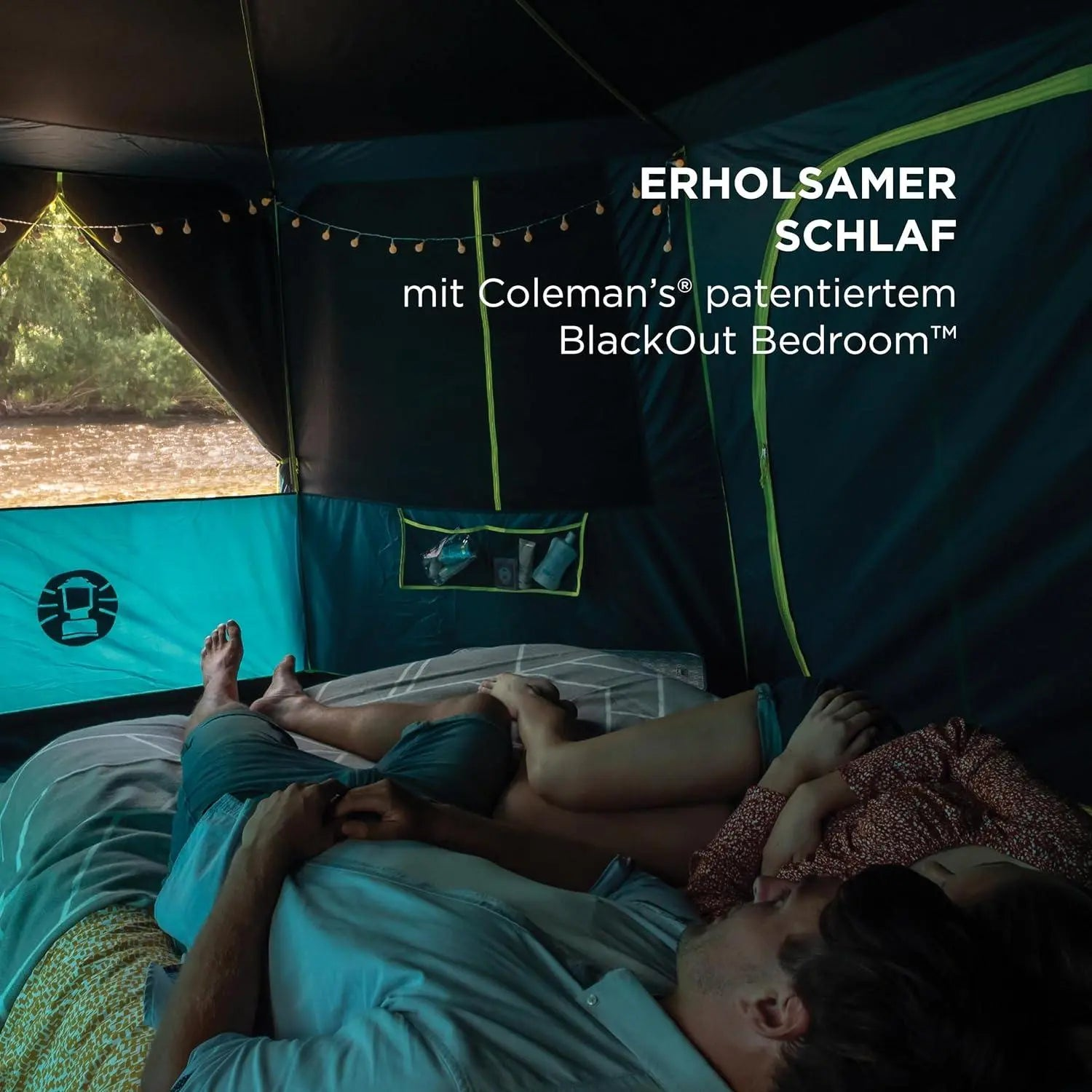 Paar liegt in einem Zelt auf einem Bett, das von Lichterketten beleuchtet wird.
