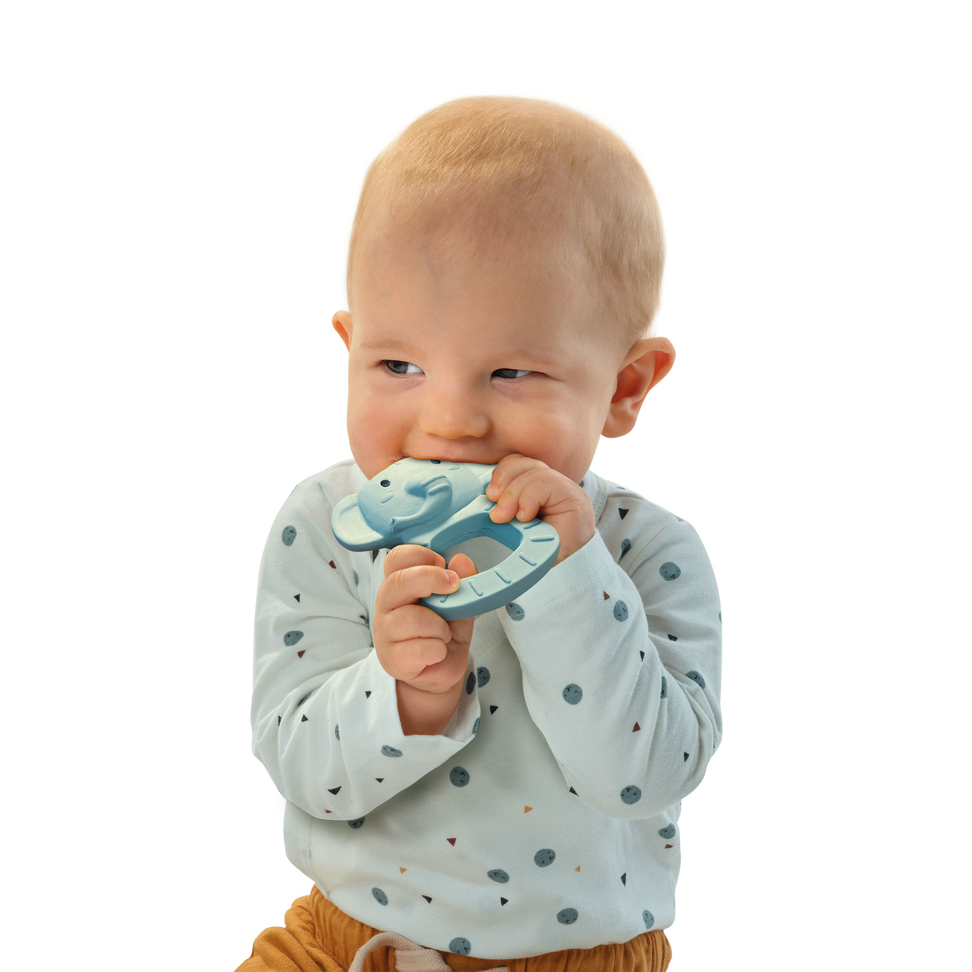 Ein Baby mit blonden Haaren kaut auf einem blauen Fisch-Beißring.