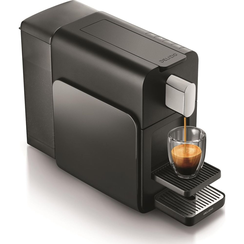 Eine schwarze Kaffeemaschine brüht Espresso in ein Glas auf weißem Hintergrund.