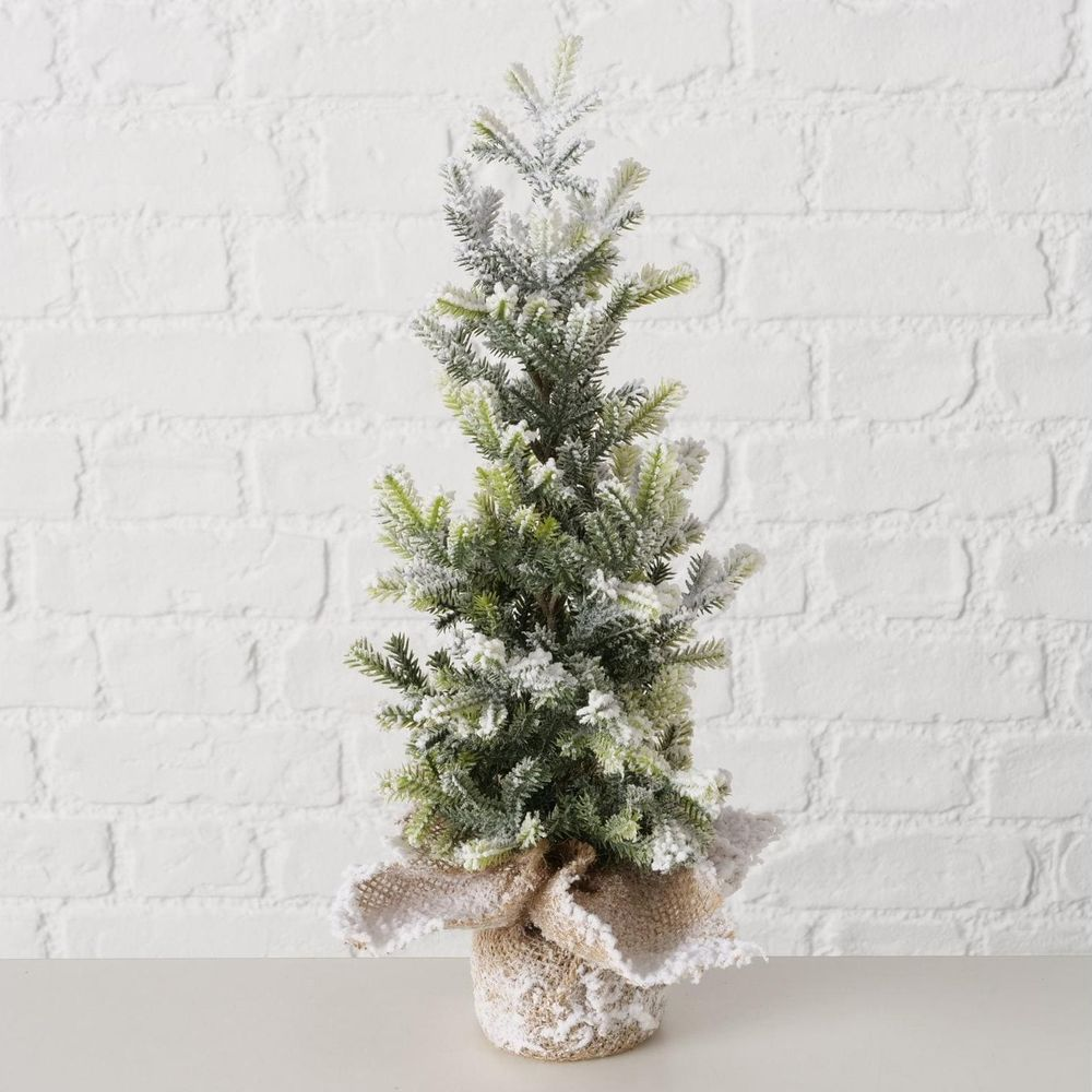 Ein kleiner künstlicher Weihnachtsbaum mit Kunstschnee bedeckt, in einem Topf mit Jute.