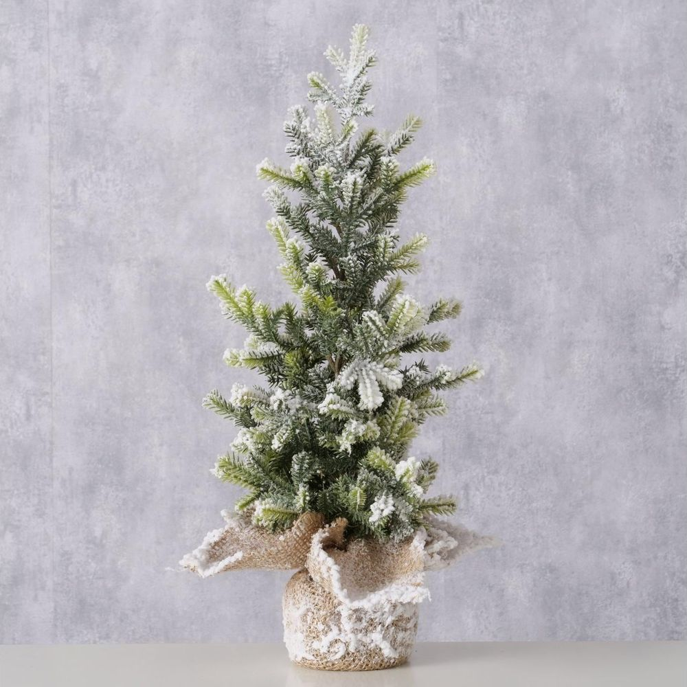 Ein kleiner, mit Schnee bedeckter Weihnachtsbaum in einem Topf mit Jute-Akzenten.