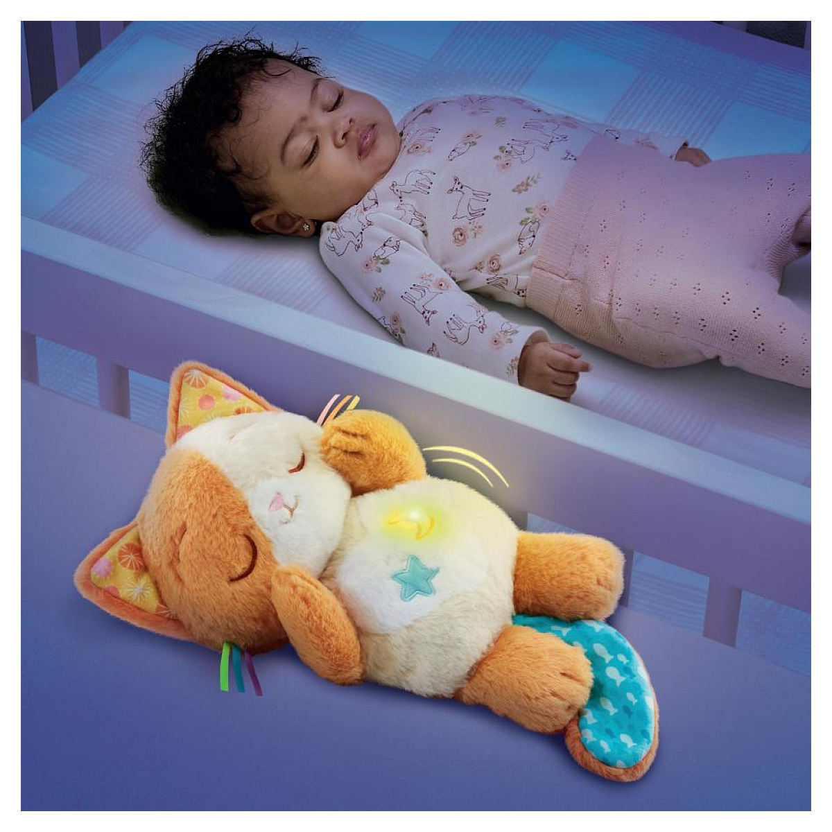 Ein Baby schläft in einem Bett neben einem beleuchteten Spielzeug in Katzenform.