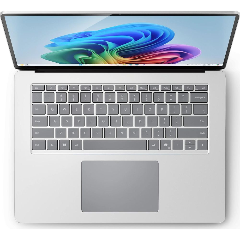 Ein silberner Laptop ist geöffnet und zeigt ein farbenfrohes abstraktes Hintergrundbild auf dem Bildschirm und eine vollständige Tastatur.