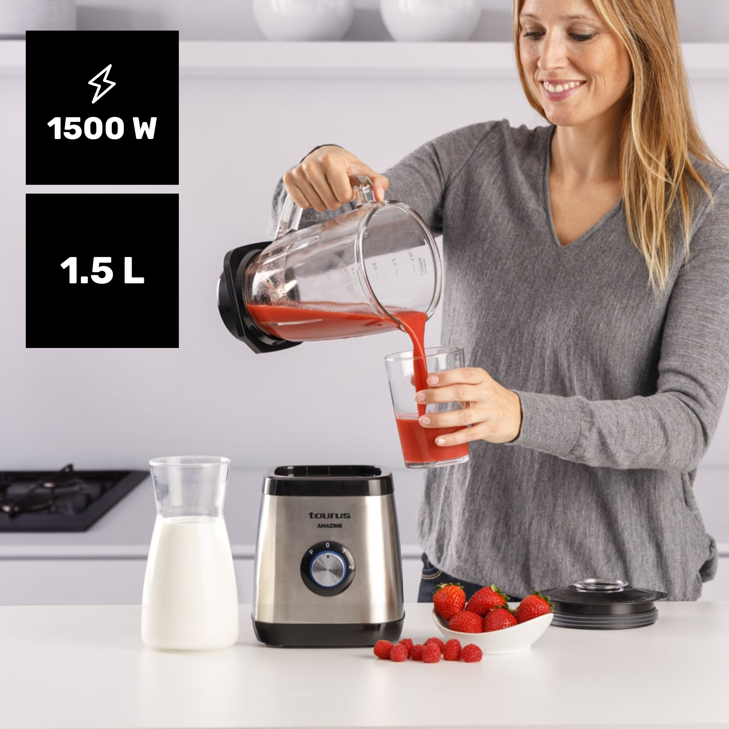 Mujer vierte jugo rojo de jarra de licuadora en vaso. Licuadora, leche, fresas, frambuesas.