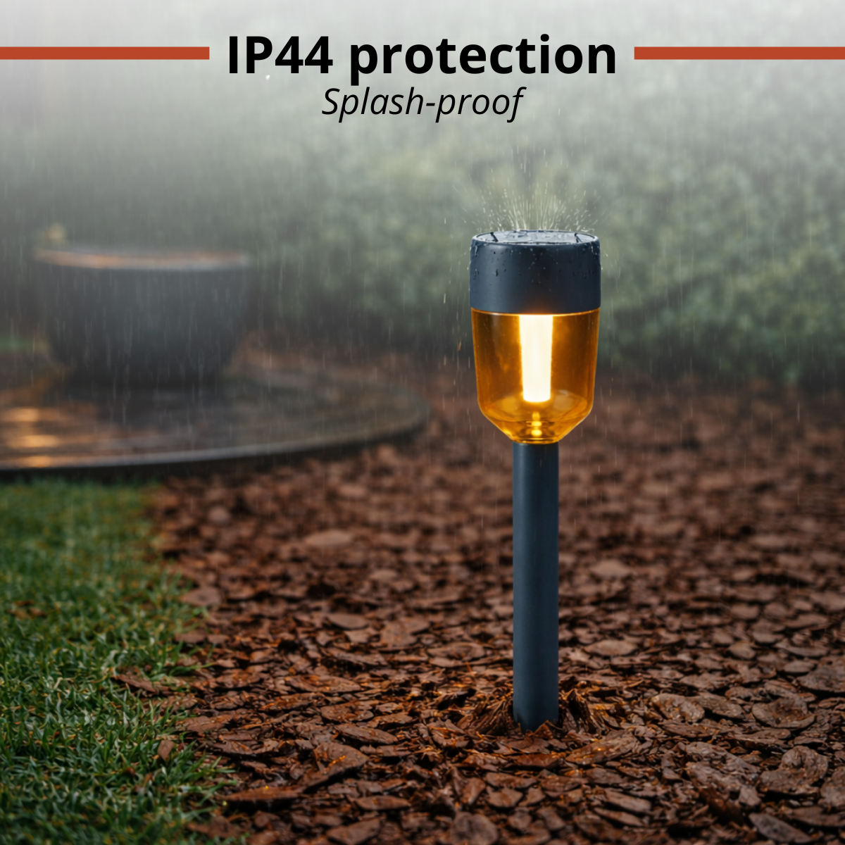 Garden lamp with yellow light on a bark mulch path in the rain.