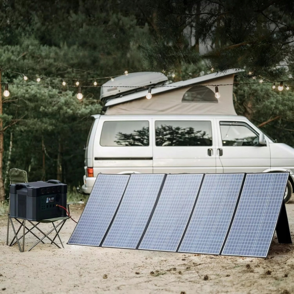 Kamper stoi na piaszczystej plaży z panelami słonecznymi i power station.