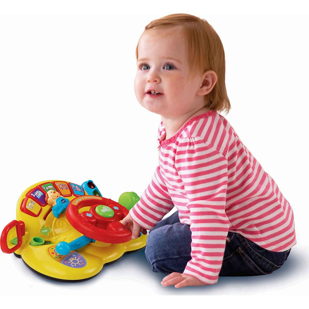 Ein Baby mit einem gestreiften Oberteil spielt mit einem bunten Spielzeuglenkrad.