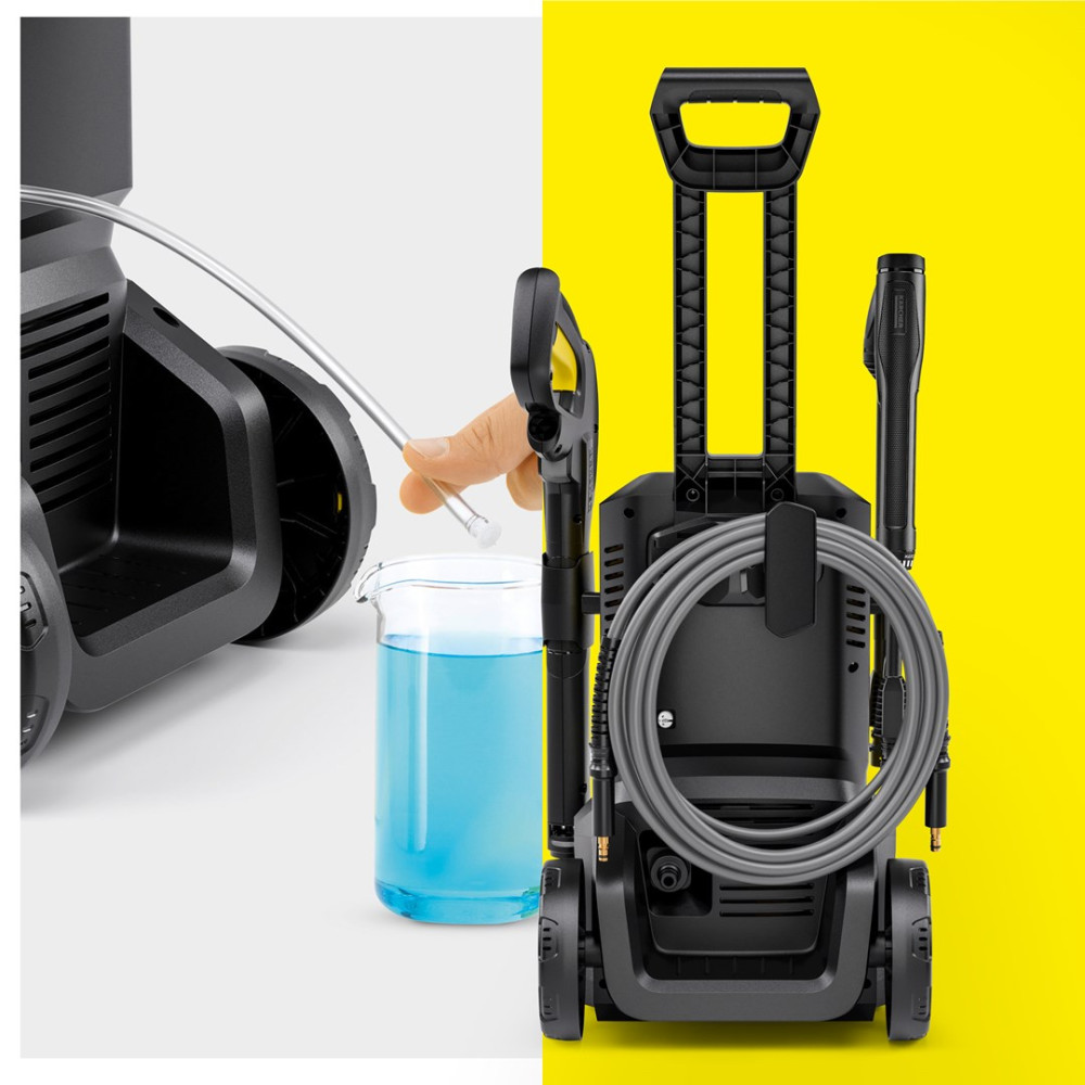 Dłoń trzyma dyszę nad zlewką z niebieskim płynem. Po prawej myjka wysokociśnieniowa.