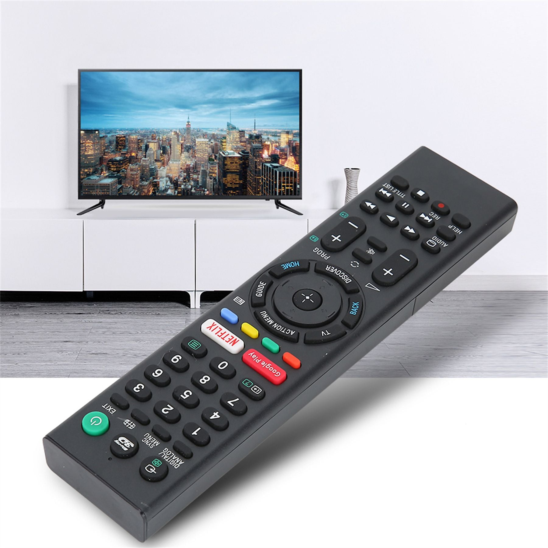 Eine schwarze Fernbedienung mit vielen Tasten liegt vor einem Fernseher mit Stadtbild.