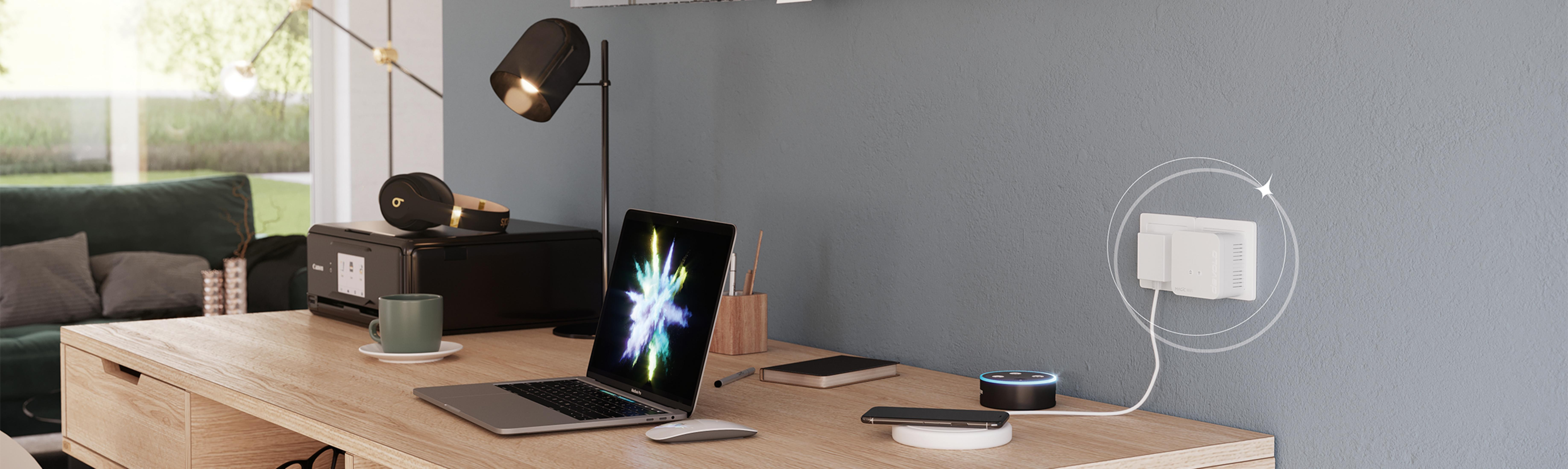 Ein Schreibtisch mit Laptop, Drucker, Kopfhörern und Smart Speaker.