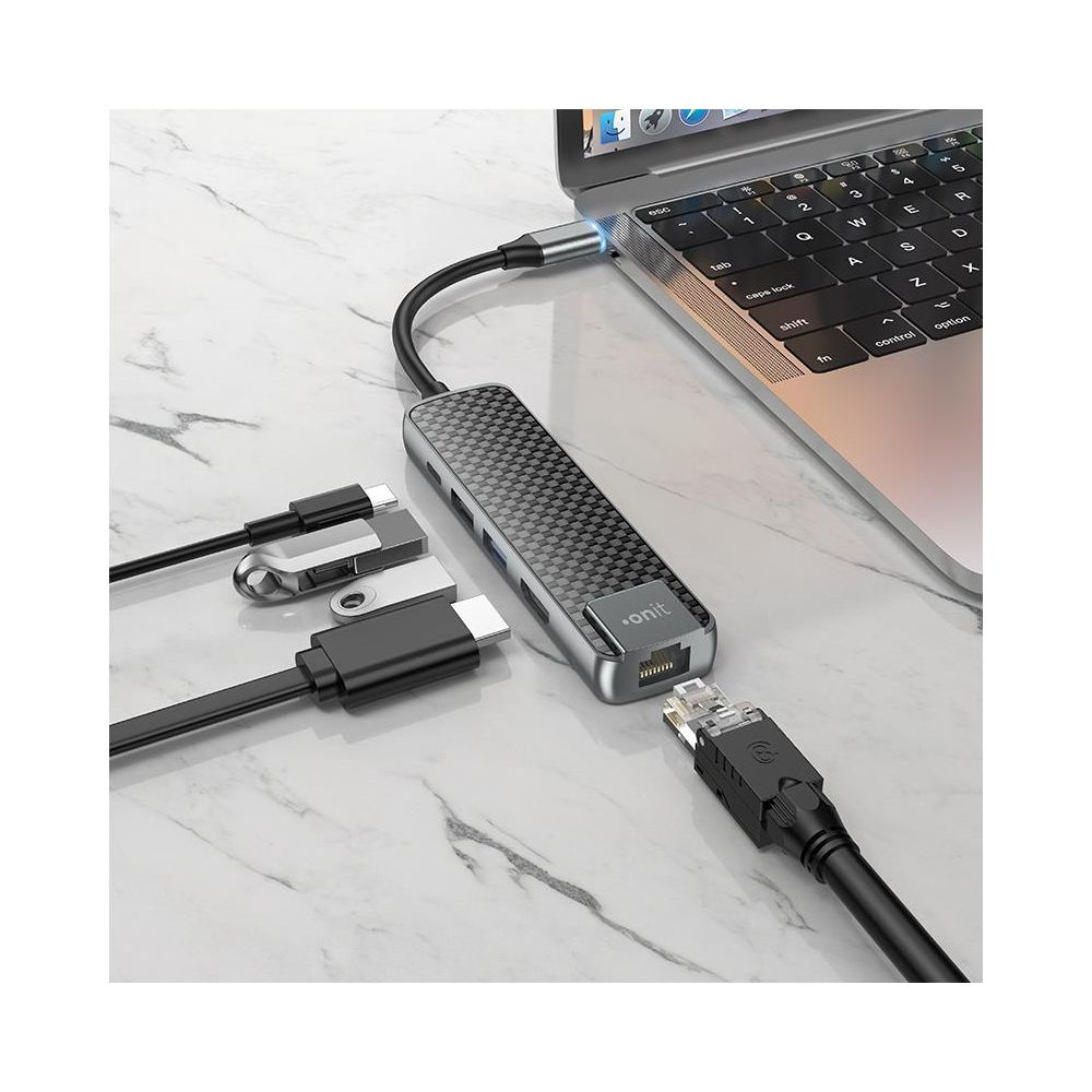 Ein USB-C-Hub mit Carbonmuster ist an einen Laptop angeschlossen.