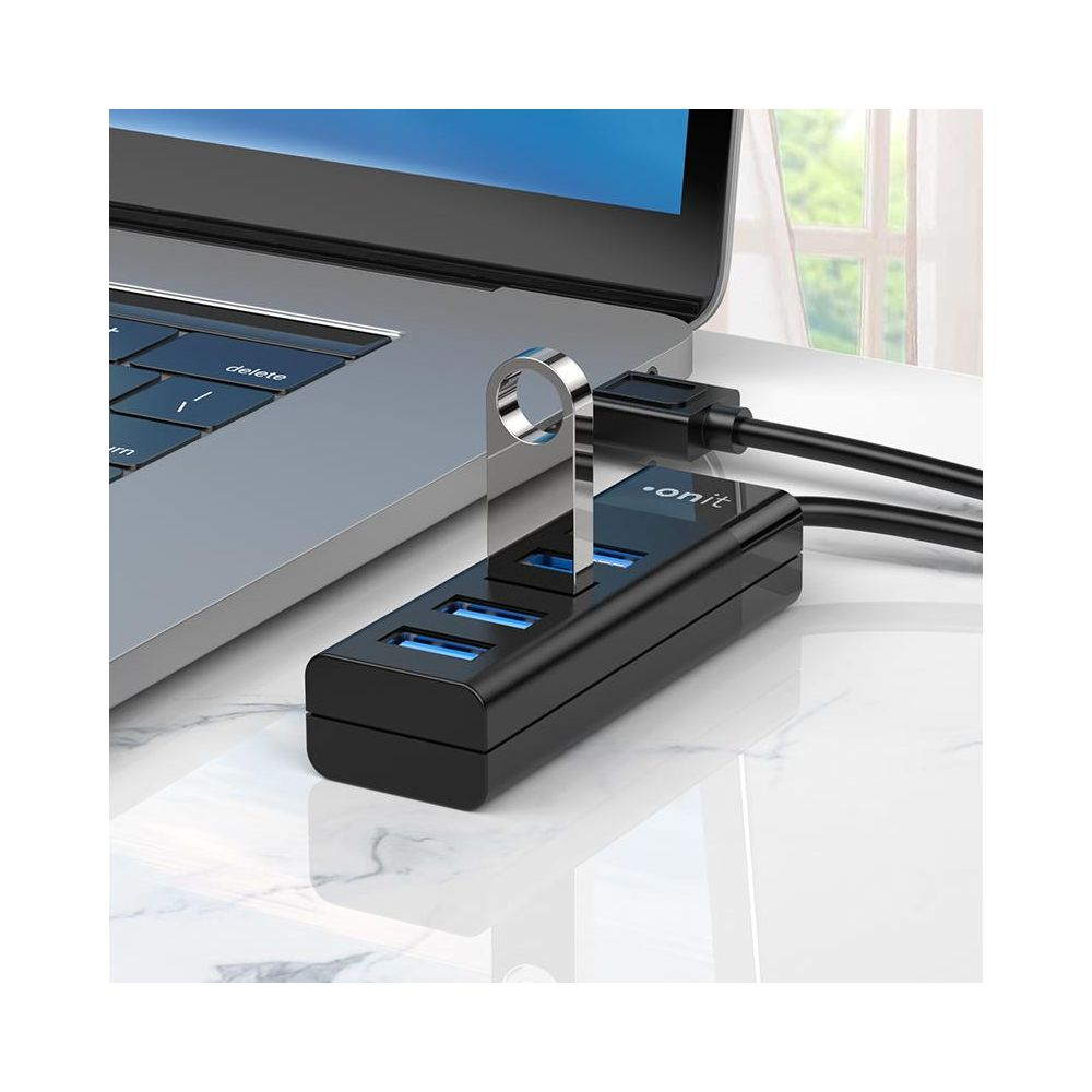 Ein schwarzer USB-Hub mit drei blauen Anschlüssen, angeschlossen an einen Laptop.