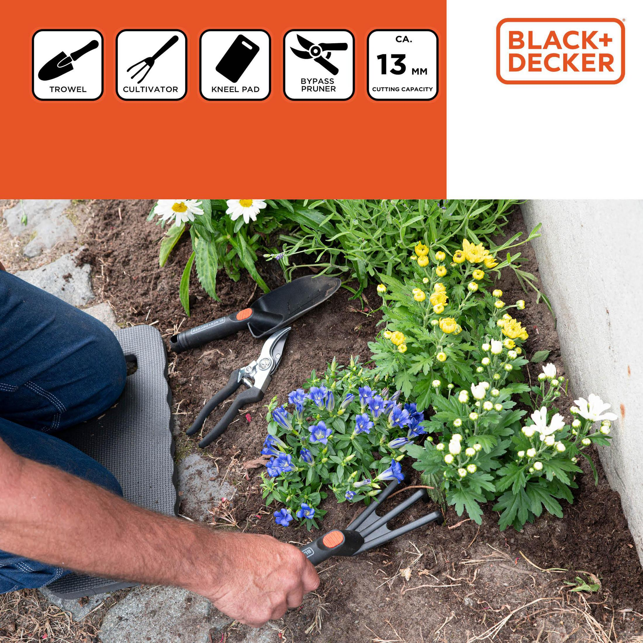 Un homme s'agenouille en jean sur un tapis de jardin, utilisant des outils.