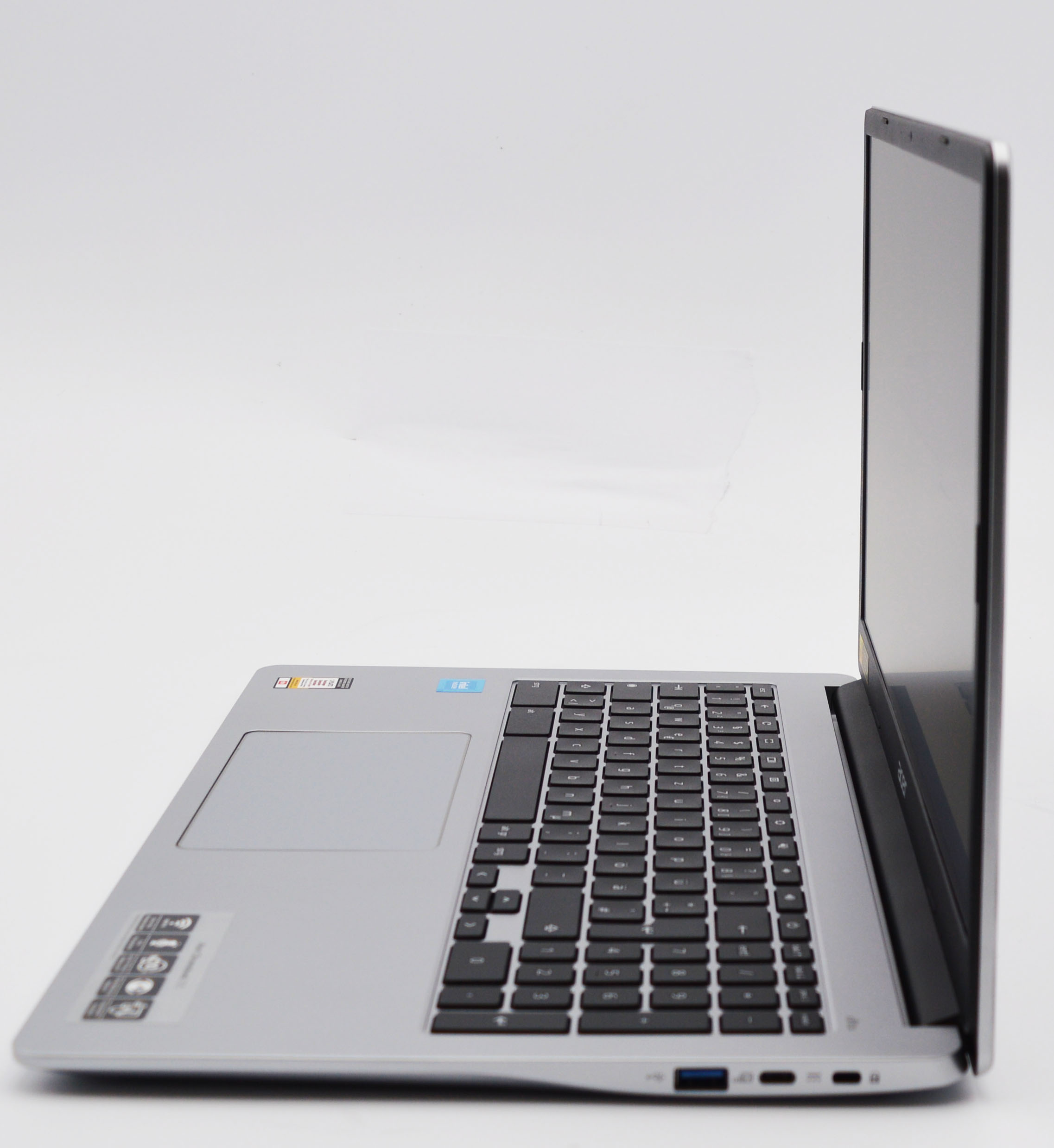 Ein silberner Laptop mit Tastatur und Touchpad, von der Seite betrachtet.