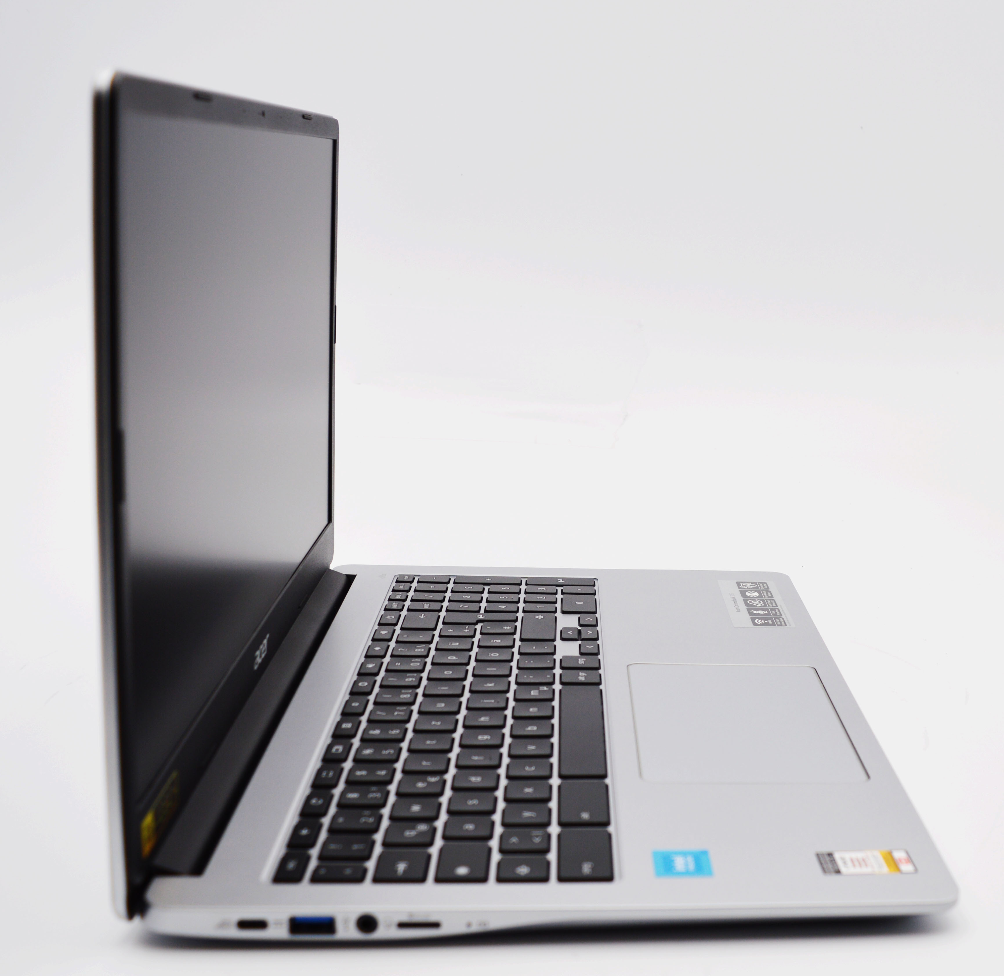 Ein silberner Laptop mit schwarzer Tastatur, von der Seite aus gesehen.