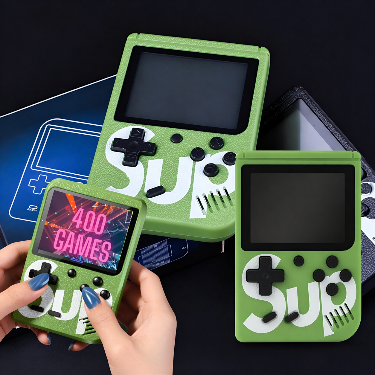 Tres consolas portátiles verdes con logo "SUP". Una sostenida, dos a su lado.