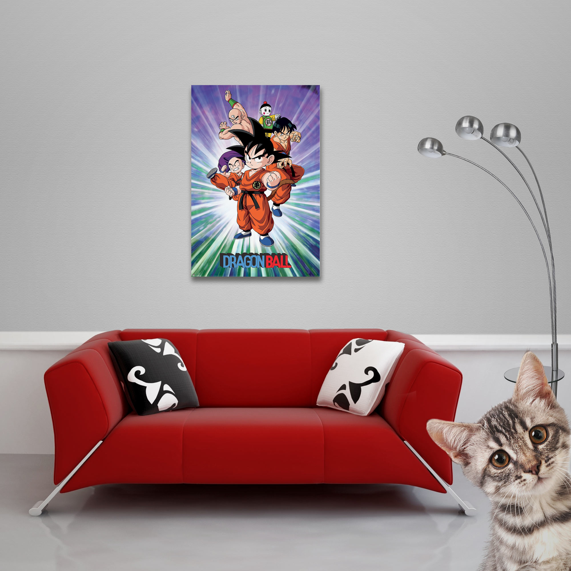 Ein rotes Sofa mit Kissen, ein Dragon Ball-Poster und eine Katze sind zu sehen.