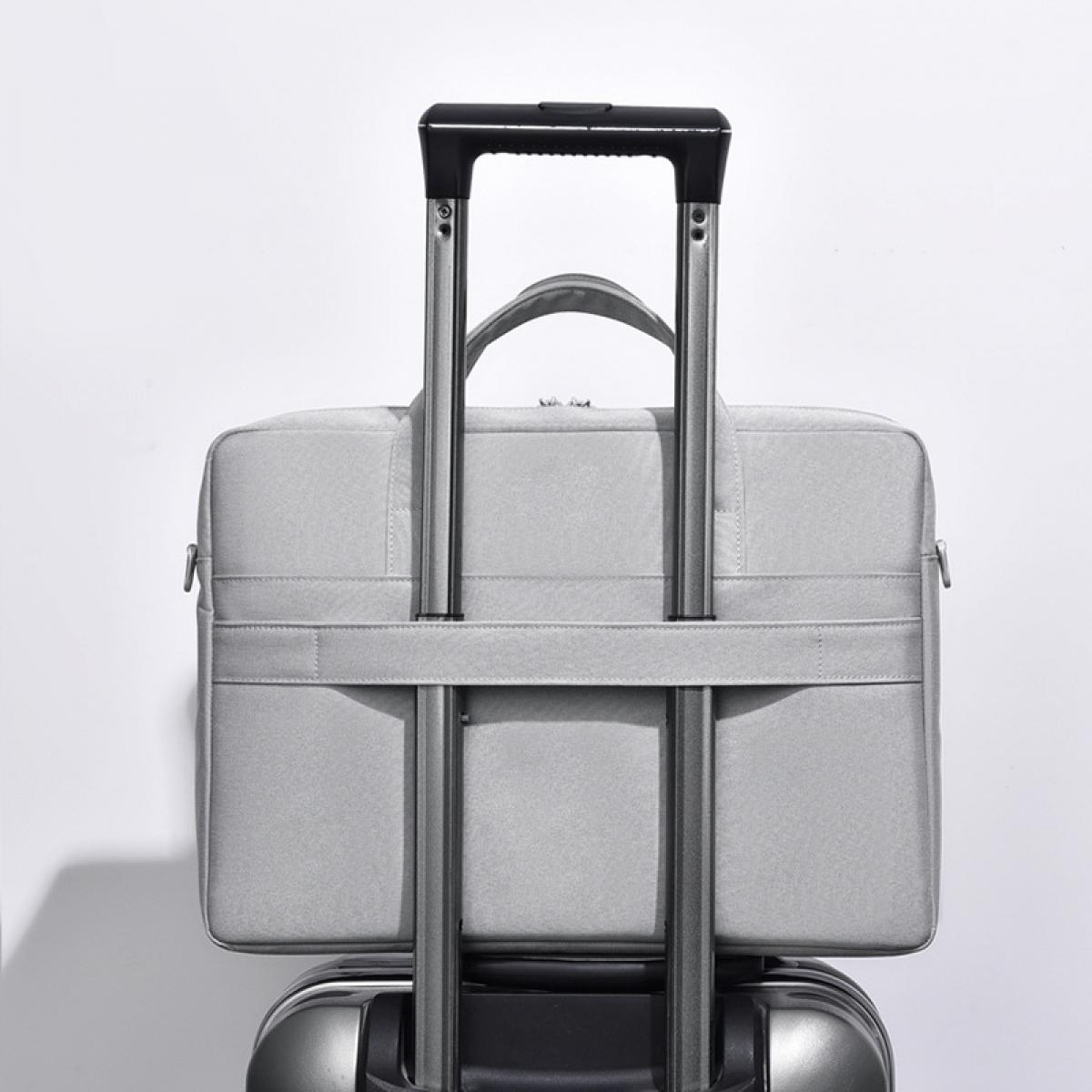 Graue Laptoptasche auf einem Koffer mit ausziehbarem Griff.