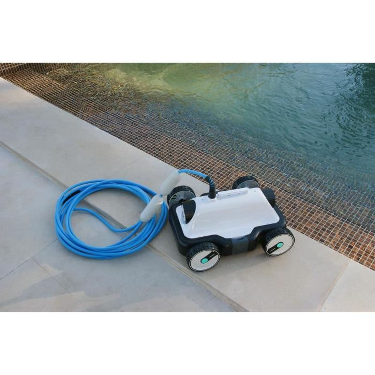 Un limpiafondos blanco con manguera azul está junto a la piscina.