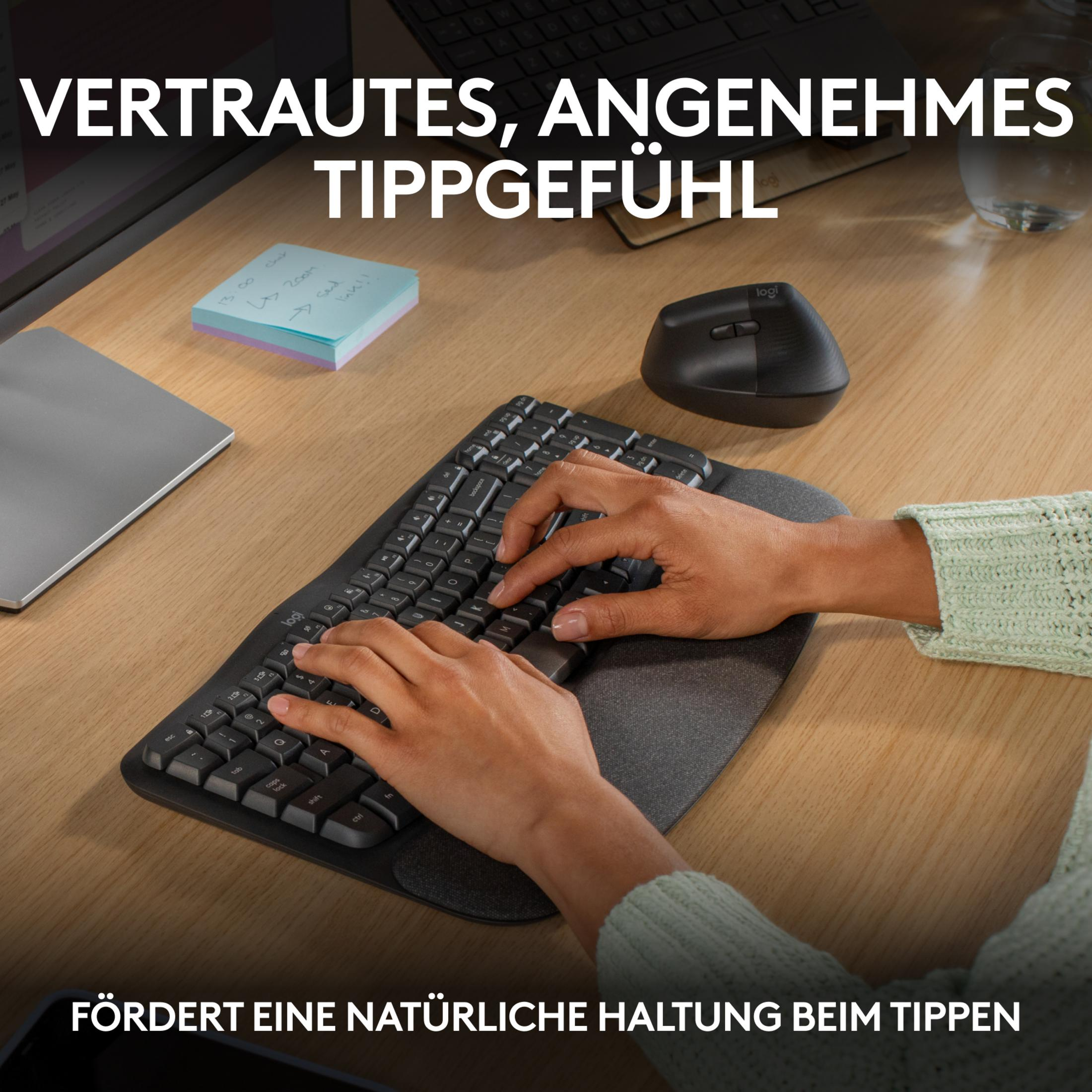 Person tippt auf einer Tastatur, daneben Maus und Notizzettel.